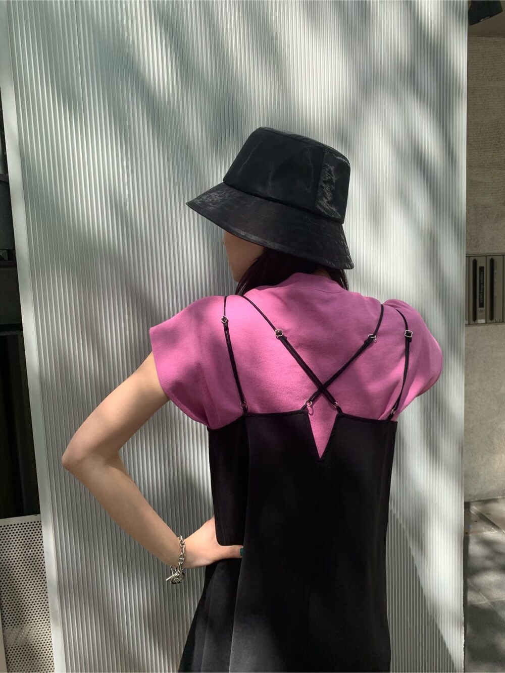 ピンク系のタンクトップ、ブラック系のワンピース、ブラック系のサンダルを着用したレディースの夏コーディネートの5枚目の写真