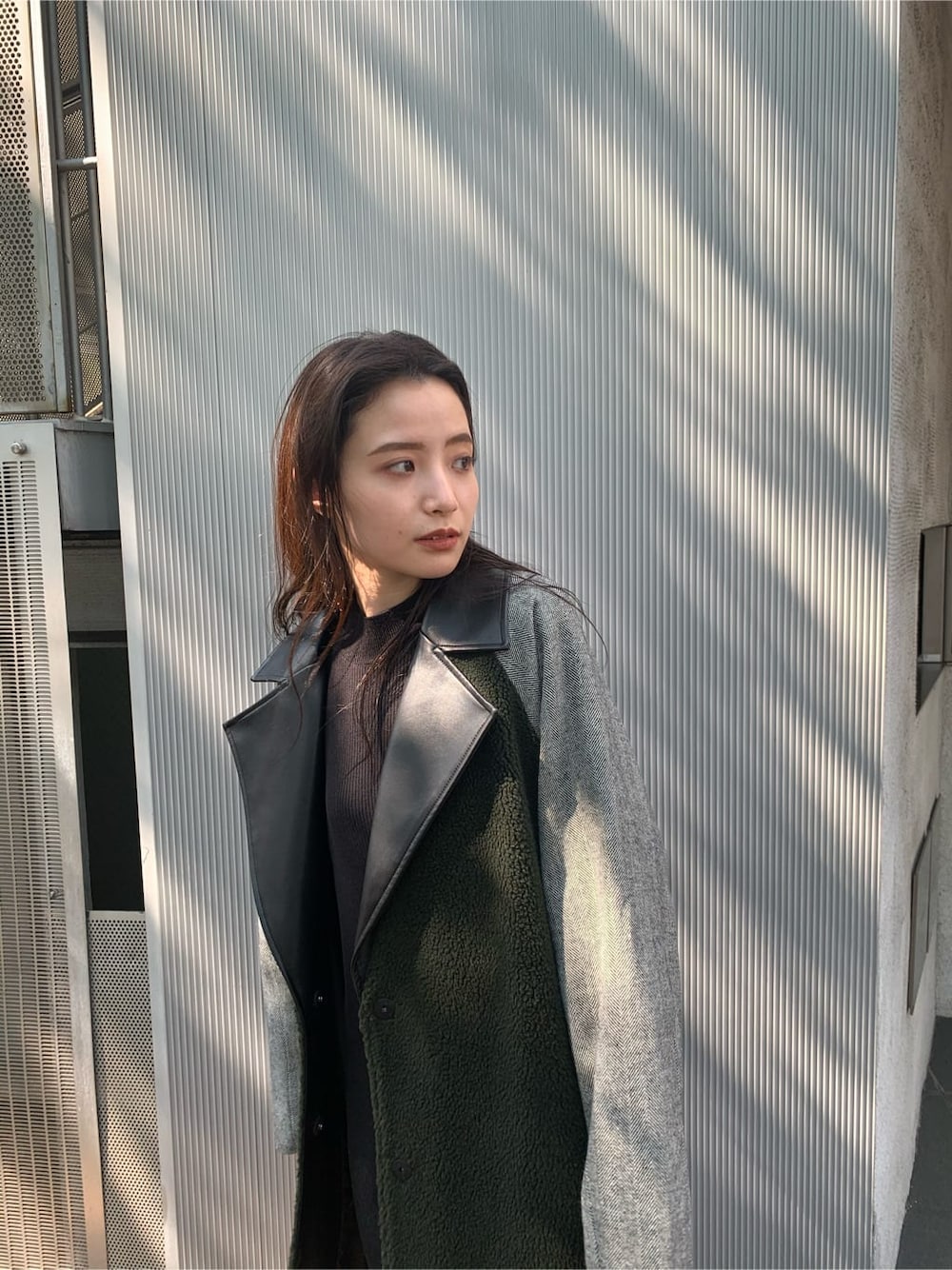 ブラック系のチェスターコート、ブラック系のワンピース、ブラック系のブーツを着用したレディースの秋コーディネートの2枚目の写真