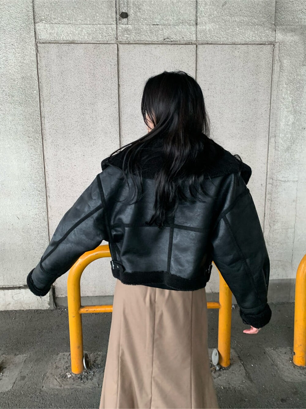 ブラウン系のスカート、ブラック系のブーツ、ブラック系のニット/セーターを着用したレディースの秋コーディネートの5枚目の写真