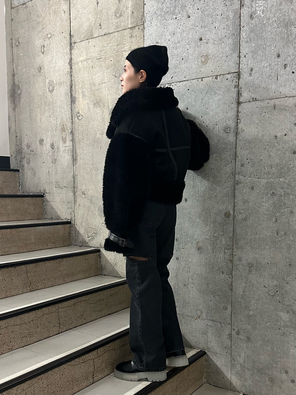 ブラック系のムートンコート、その他のニット/セーター、ブラック系のデニムパンツを着用したレディースの秋コーディネートの3枚目の写真