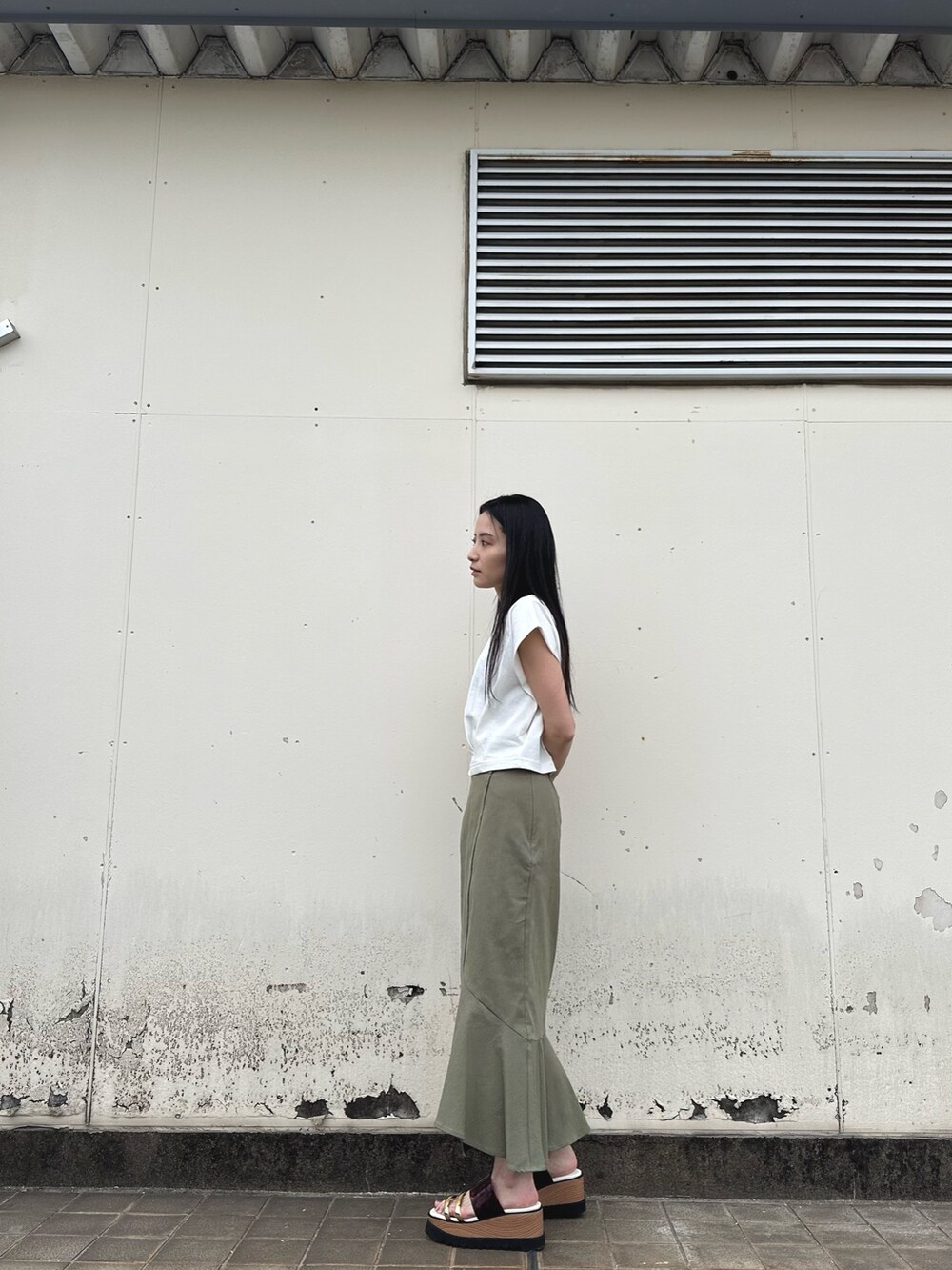 ホワイト系のTシャツ/カットソー、グリーン系のスカート、その他のサンダルを着用したレディースの春コーディネートの4枚目の写真