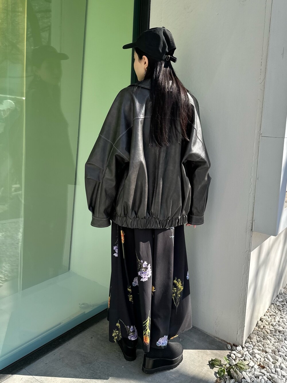 グレー系のブルゾン、ブラック系のスカート、ブラック系のブーツを着用したレディースの冬コーディネートの3枚目の写真