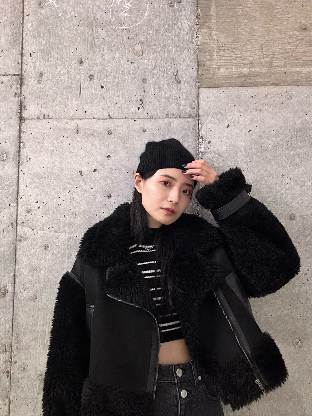 ブラック系のムートンコート、その他のニット/セーター、ブラック系のデニムパンツを着用したレディースの秋コーディネートの4枚目の写真