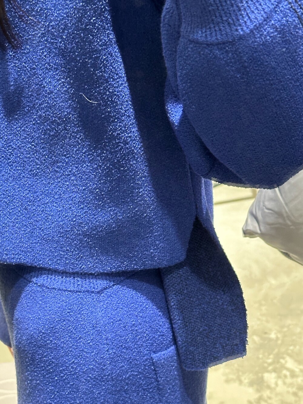 ブルー系のニット/セーター、ブルー系のスカート、ブラック系のブーツを着用したレディースの冬コーディネートの7枚目の写真