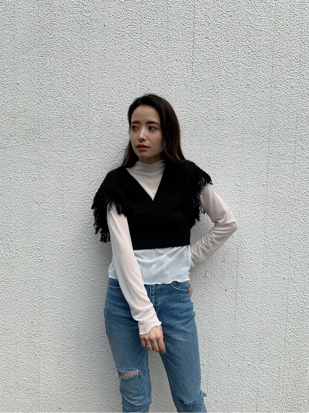 ブルー系のデニムパンツ、ブラック系のサンダル、ブラック系のニット/セーターを着用したレディースの春コーディネートの2枚目の写真