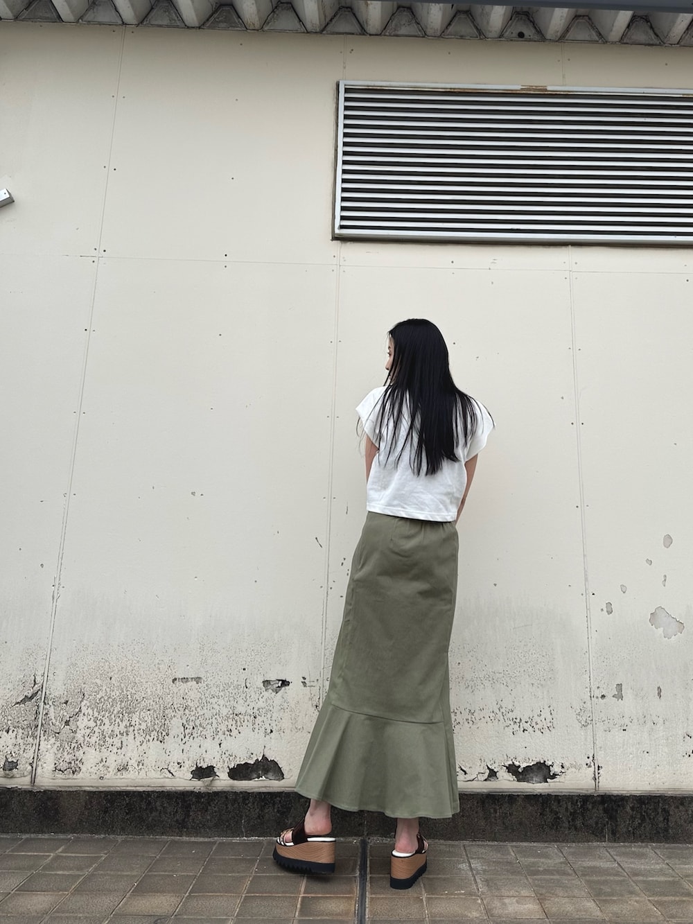 ホワイト系のTシャツ/カットソー、グリーン系のスカート、その他のサンダルを着用したレディースの春コーディネートの3枚目の写真