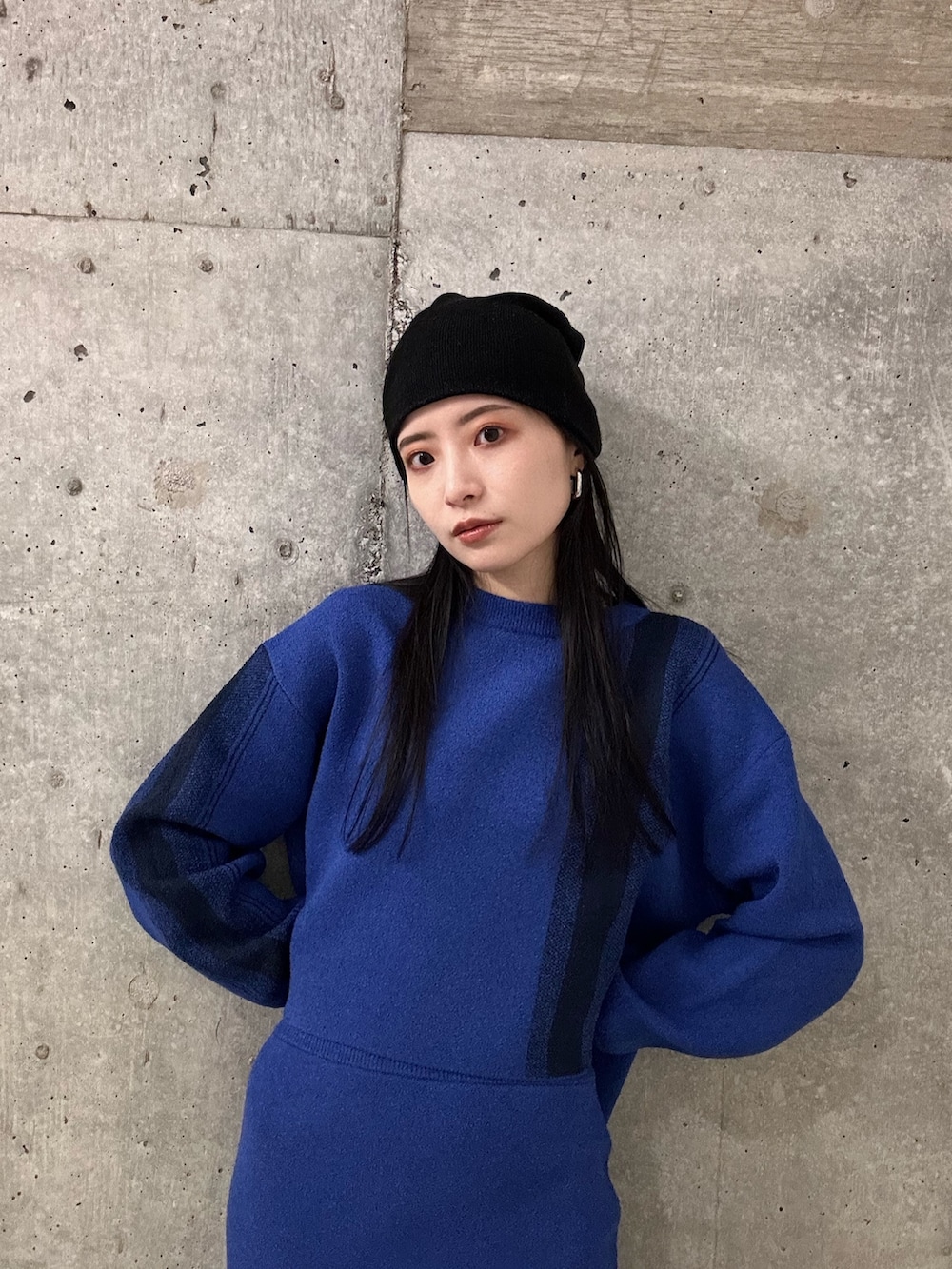 ブルー系のニット/セーター、ブルー系のスカート、ブラック系のブーツを着用したレディースの冬コーディネートの4枚目の写真