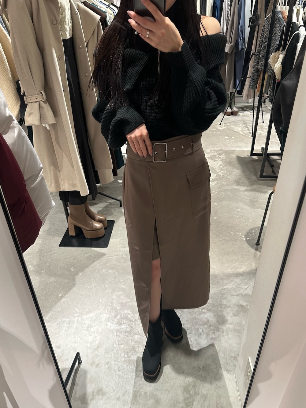 ブラウン系のスカート、ブラック系のニット/セーター、ブラック系のブーツを着用したレディースの冬コーディネートの7枚目の写真