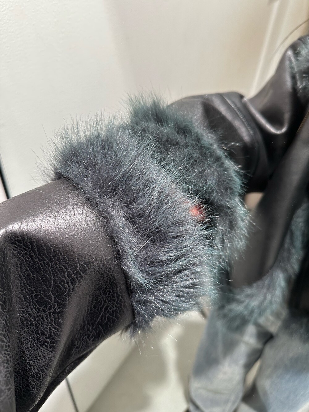 グレー系のデニムパンツ、ブラック系のブーツ、ブラック系のムートンコートを着用したレディースの夏コーディネートの7枚目の写真