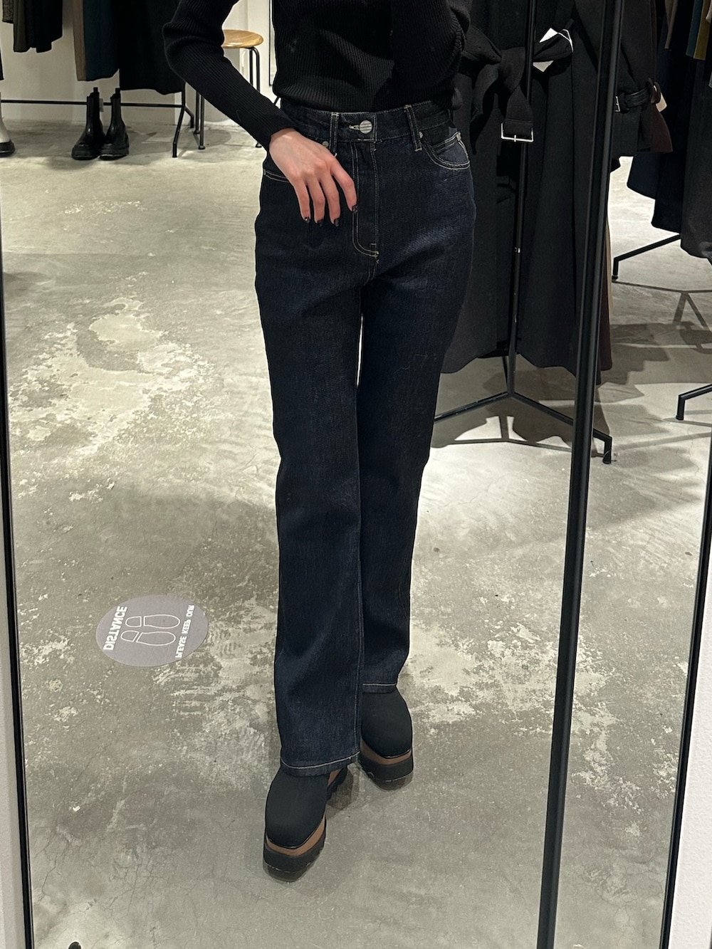 ブラック系のブーツ、ブラック系のチェスターコート、ブラック系のニット/セーターを着用したレディースの冬コーディネートの7枚目の写真