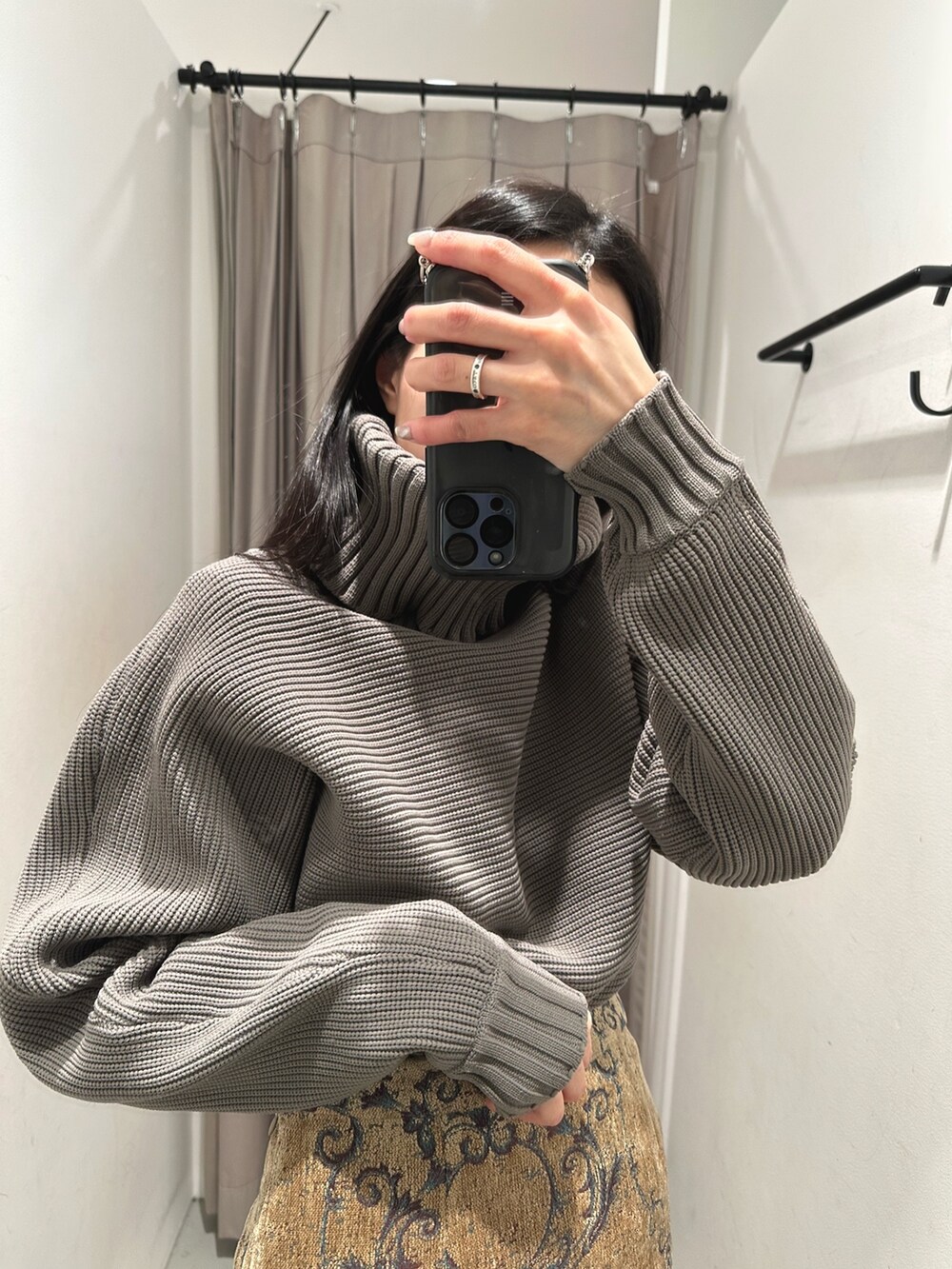 ベージュ系のニット/セーター、ブラウン系のスカートを着用したレディースの冬コーディネートの2枚目の写真