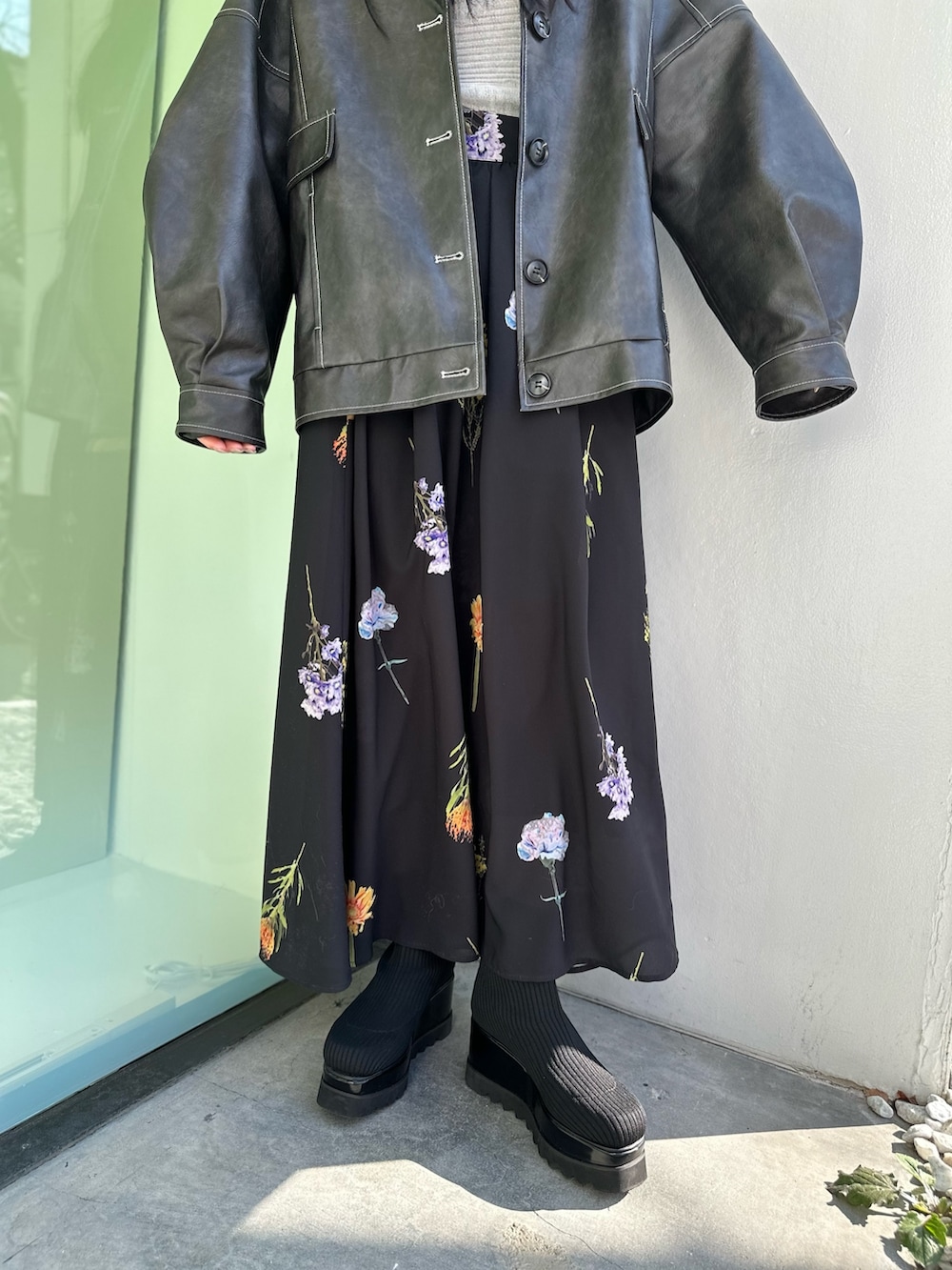 グレー系のブルゾン、ブラック系のスカート、ブラック系のブーツを着用したレディースの冬コーディネートの5枚目の写真