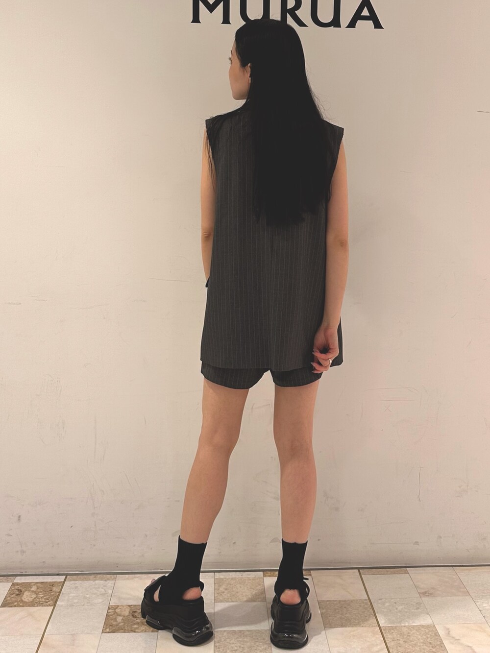 グレー系のその他パンツ、グレー系のベスト、ブルー系のタンクトップを着用したレディースの夏コーディネートの3枚目の写真