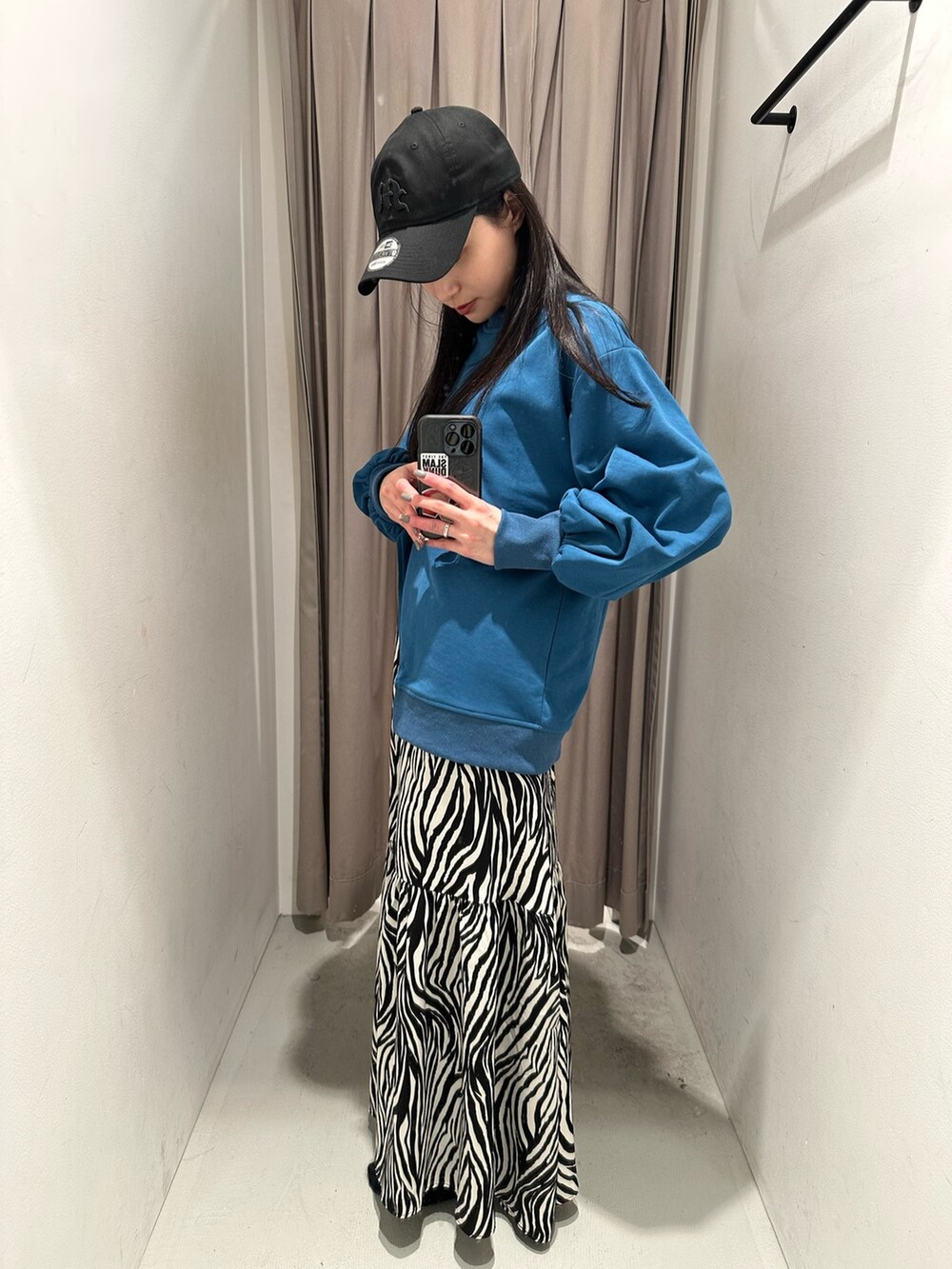 ブルー系のTシャツ/カットソー、ホワイト系のスカート、ブラック系のキャップを着用したレディースの春コーディネートの9枚目の写真