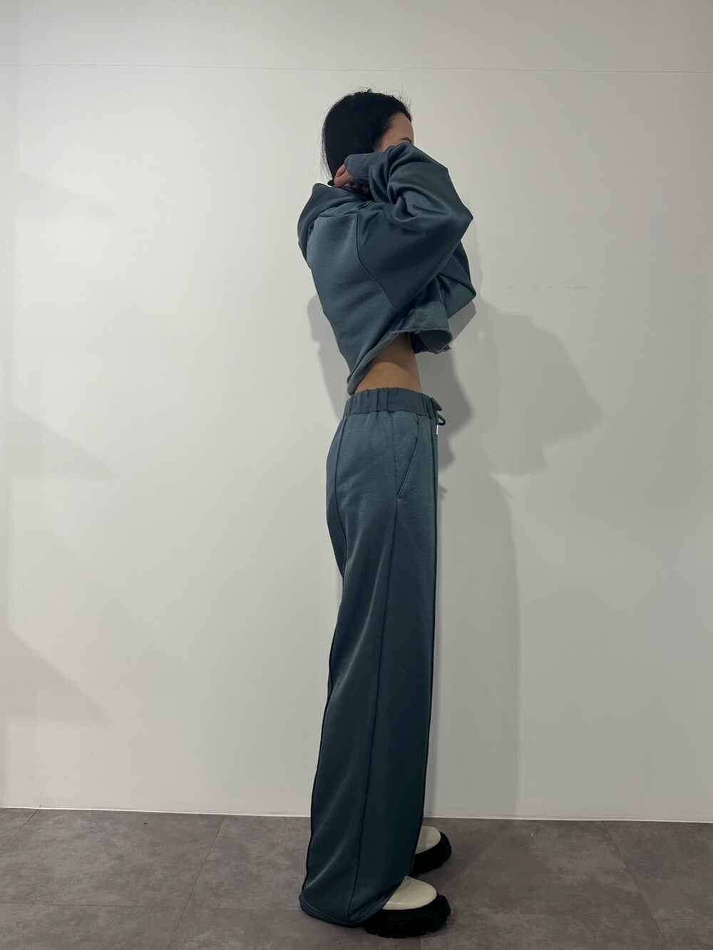 ブルー系のその他パンツ、ブルー系のTシャツ/カットソー、ホワイト系のブーツを着用したレディースの冬コーディネートの2枚目の写真