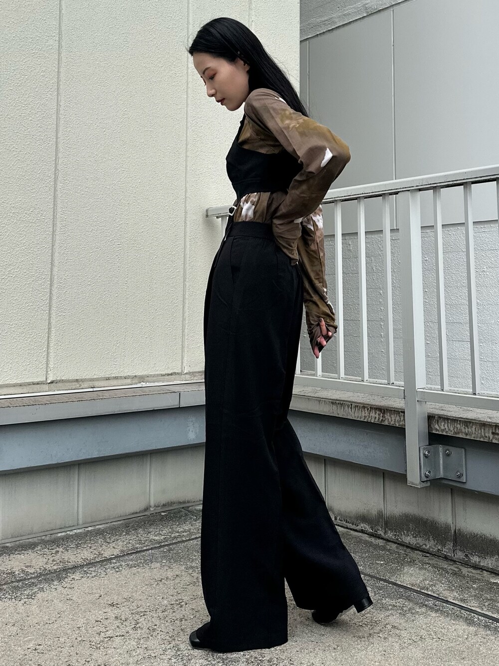 ブラック系のつなぎ/オールインワン、ブラウン系のTシャツ/カットソー、ブラック系のブーツを着用したレディースの秋コーディネートの3枚目の写真