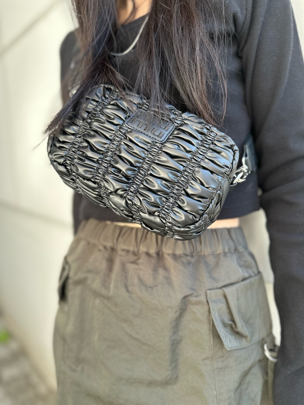 ベージュ系のスカート、ブラック系のTシャツ/カットソー、ブラック系のブーツを着用したレディースの冬コーディネートの6枚目の写真