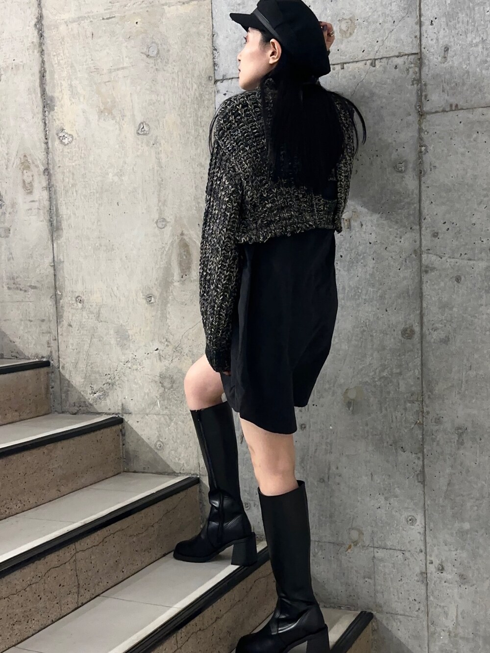 ブラック系のワンピース、ブラック系のブーツを着用したレディースの秋コーディネートの3枚目の写真