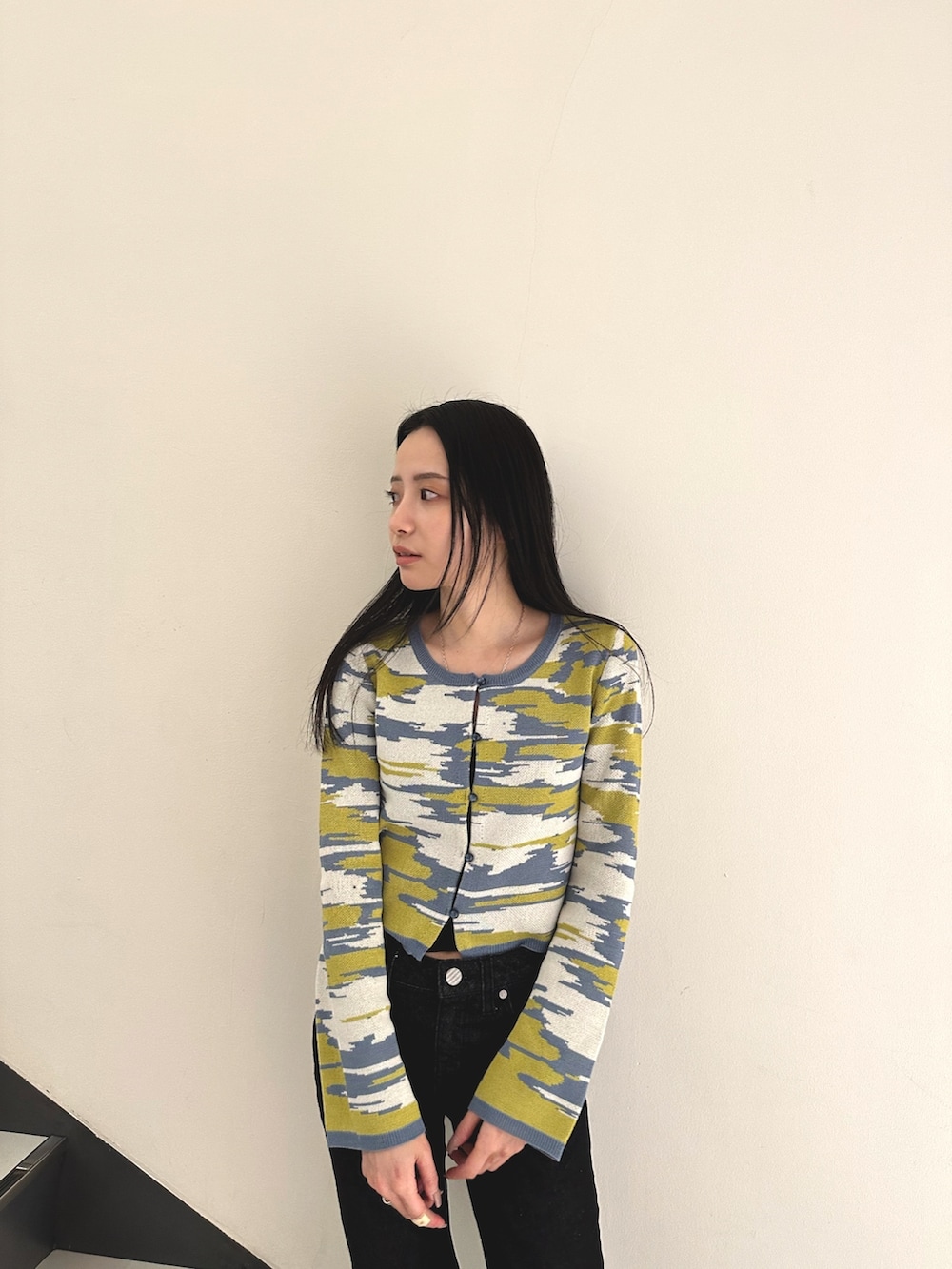 イエロー系のカーディガン/ボレロ、ブラック系のデニムパンツ、ホワイト系のローファーを着用したレディースの冬コーディネートの4枚目の写真