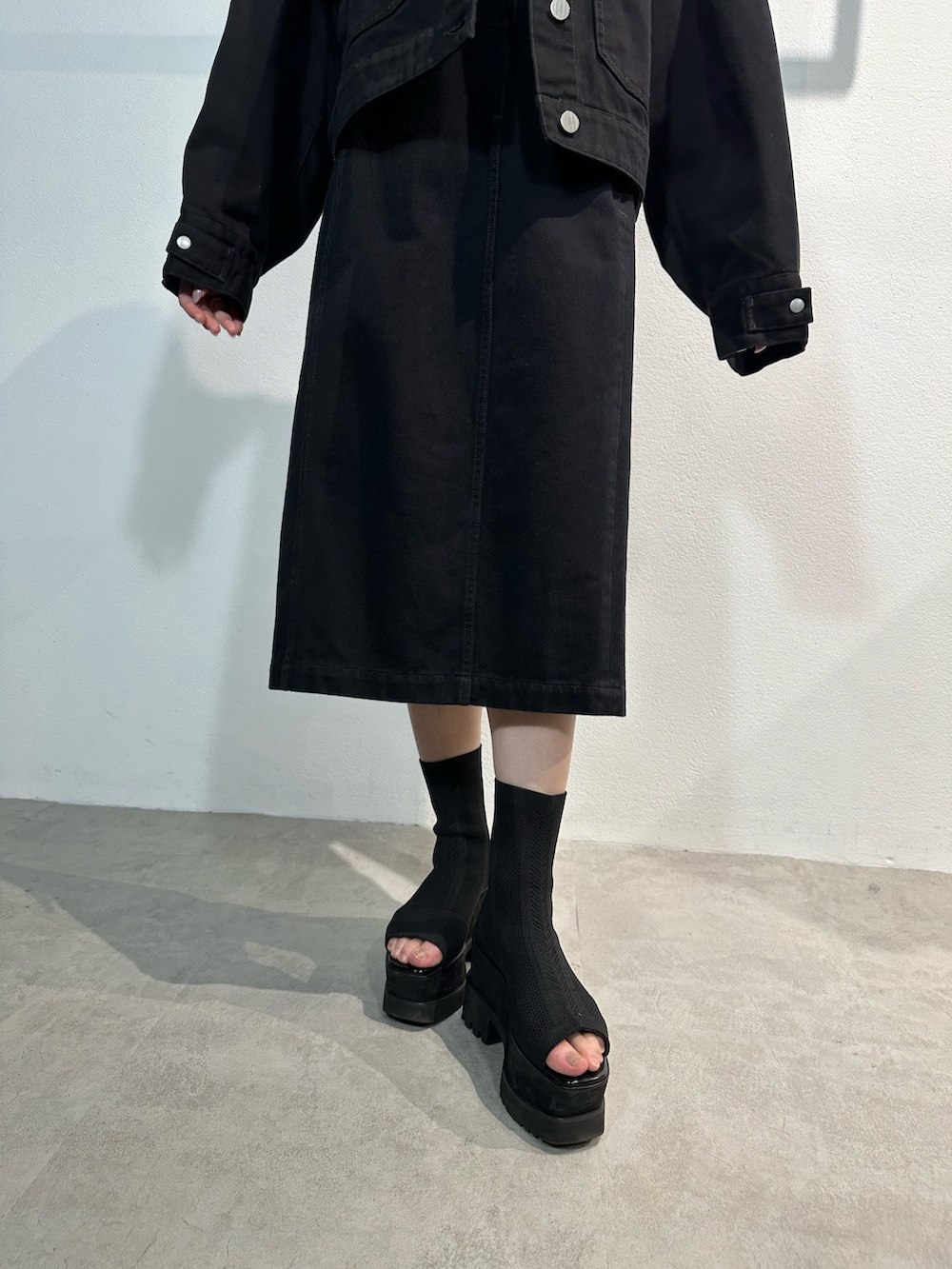 ブラック系のワンピース、ブラック系のデニムジャケット、ブラック系のブーツを着用したレディースの冬コーディネートの6枚目の写真