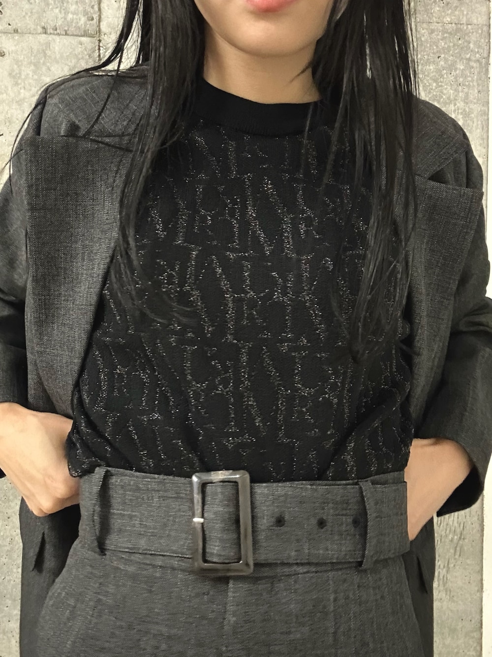 グレー系のスラックス、ブラック系のブーツ、グレー系のテーラードジャケットを着用したレディースの秋コーディネートの6枚目の写真