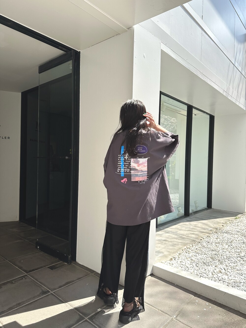 グレー系のTシャツ/カットソー、ブラック系のサンダルを着用したレディースの春コーディネートの2枚目の写真