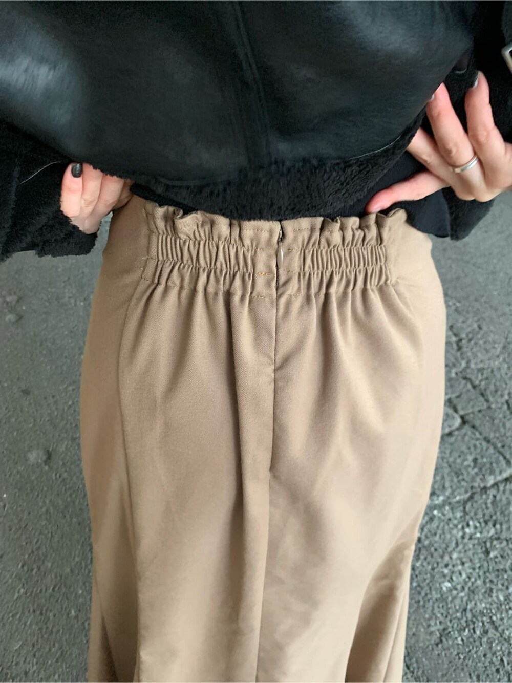 ブラウン系のスカート、ブラック系のブーツ、ブラック系のニット/セーターを着用したレディースの秋コーディネートの4枚目の写真