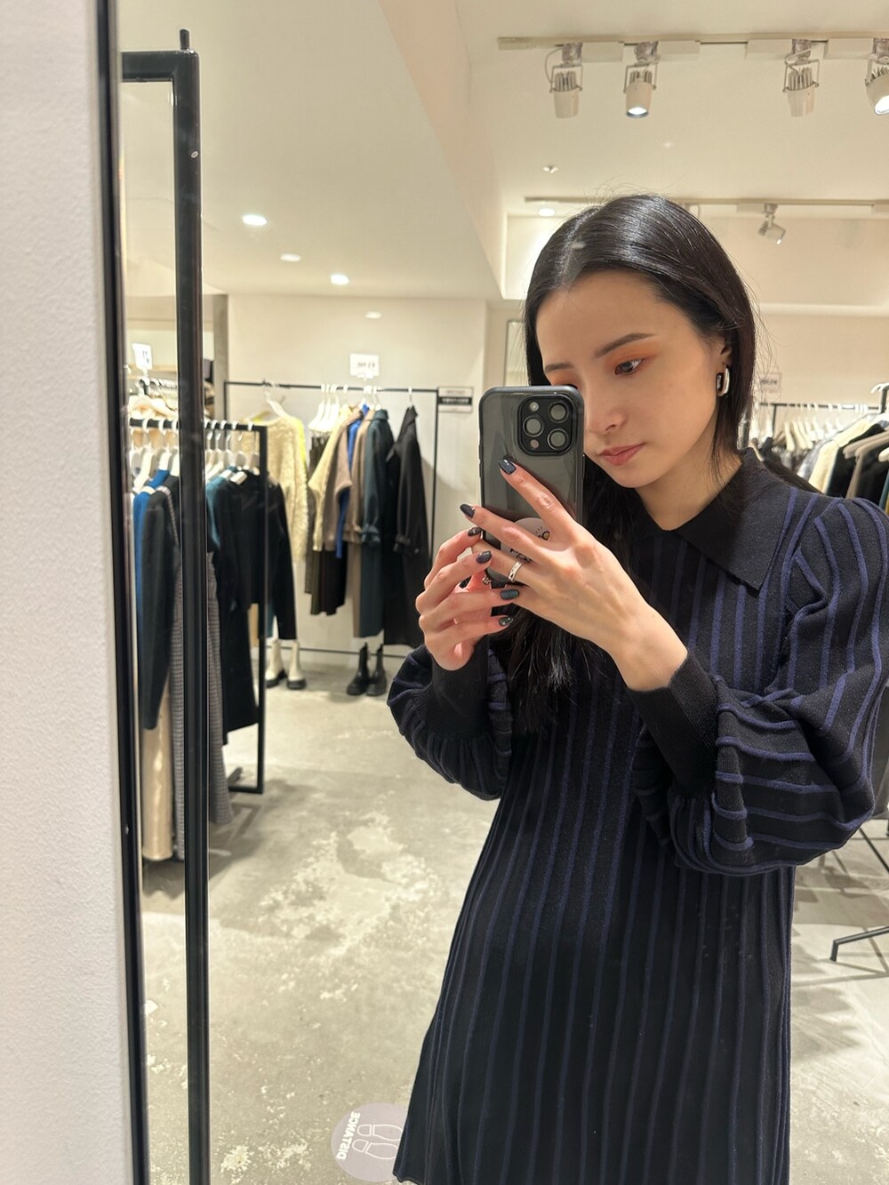 ブラック系のダウンジャケット/コート、ブラック系のブーツ、ブラック系のワンピースを着用したレディースの冬コーディネートの7枚目の写真