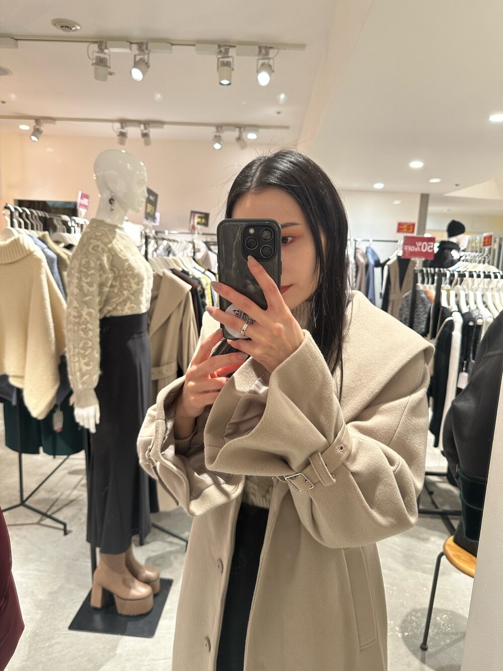 ブラック系のスカート、ホワイト系のニット/セーター、ブラウン系のブーツを着用したレディースの冬コーディネートの6枚目の写真