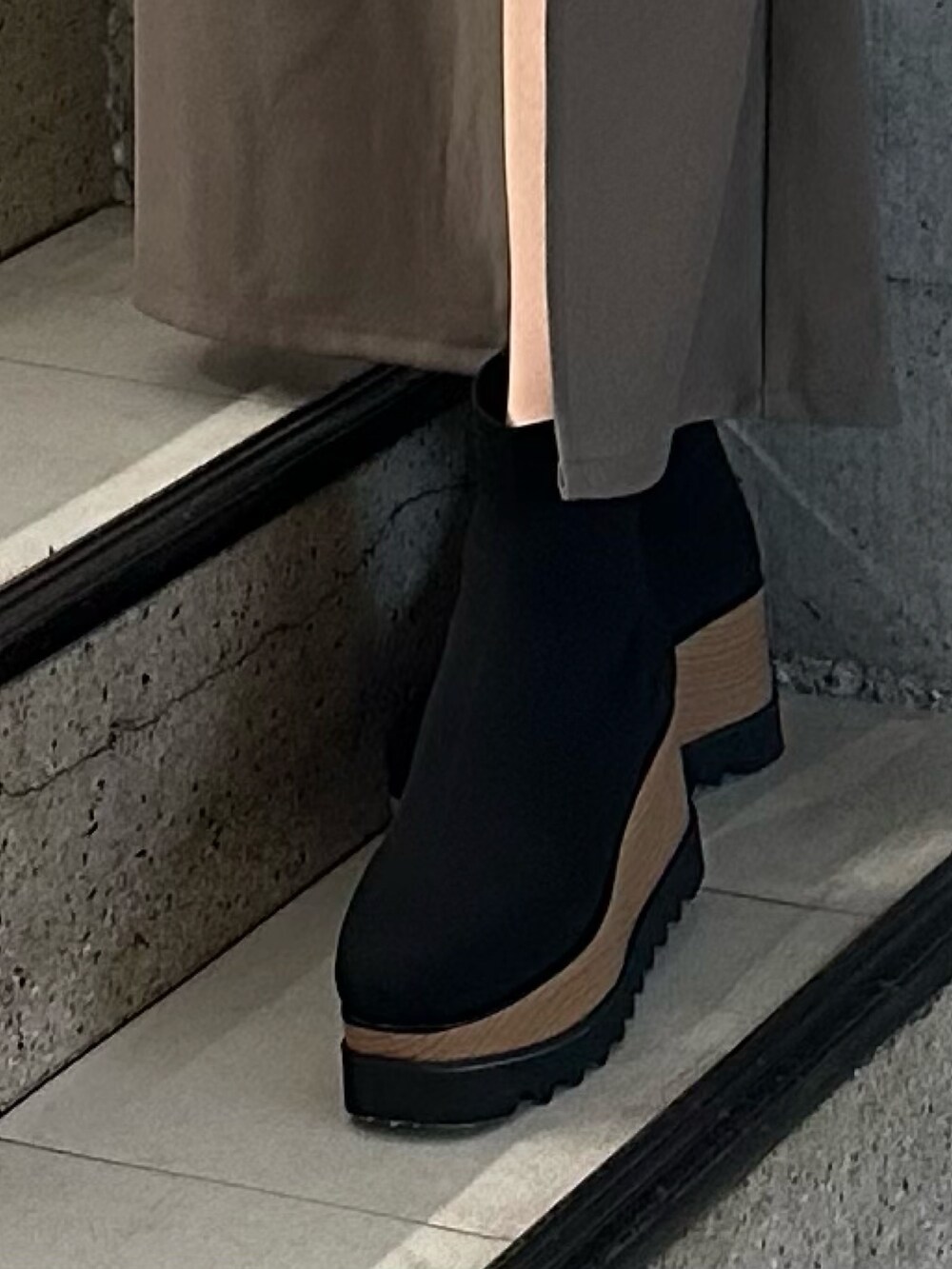 ブラウン系のスカート、ブラック系のニット/セーター、ブラック系のブーツを着用したレディースの冬コーディネートの8枚目の写真