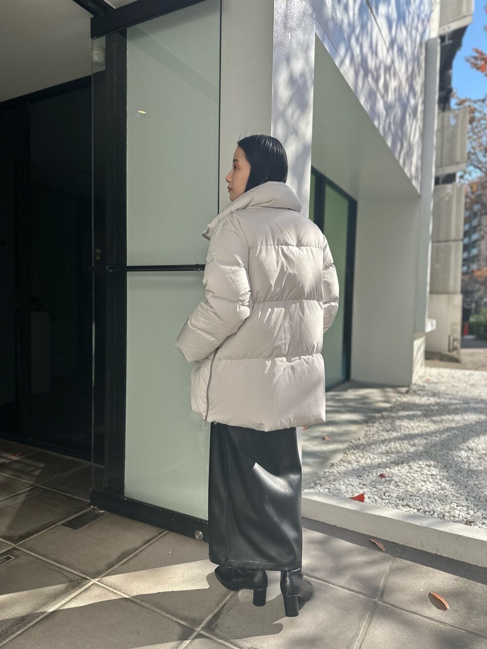 グレー系のダウンジャケット/コート、その他のニット/セーター、ブラック系のスカートを着用したレディースの冬コーディネートの3枚目の写真