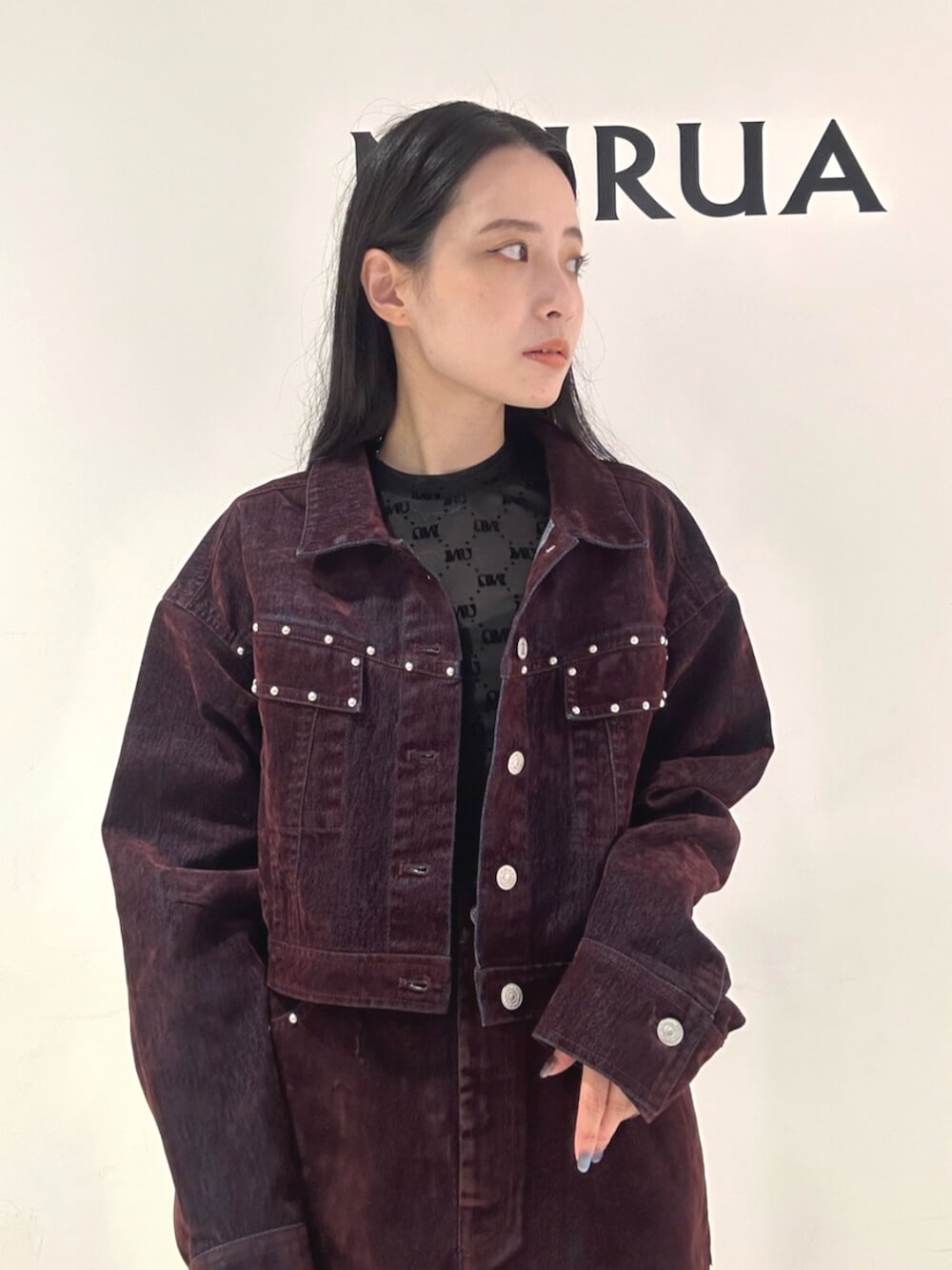 レッド系のスカート、レッド系のデニムジャケット、ブラック系のブーツを着用したレディースの夏コーディネートの6枚目の写真