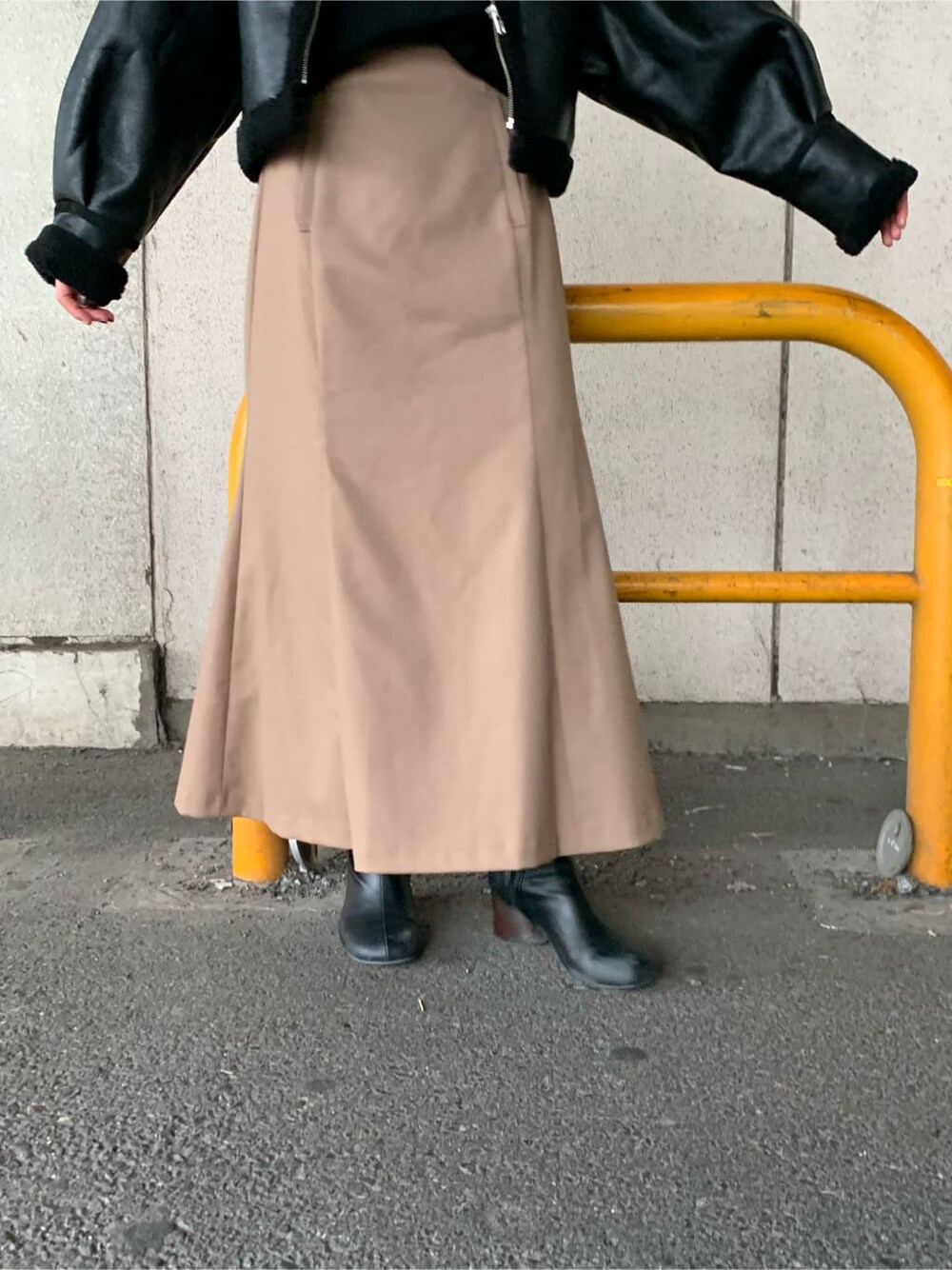 ブラウン系のスカート、ブラック系のブーツ、ブラック系のニット/セーターを着用したレディースの秋コーディネートの3枚目の写真