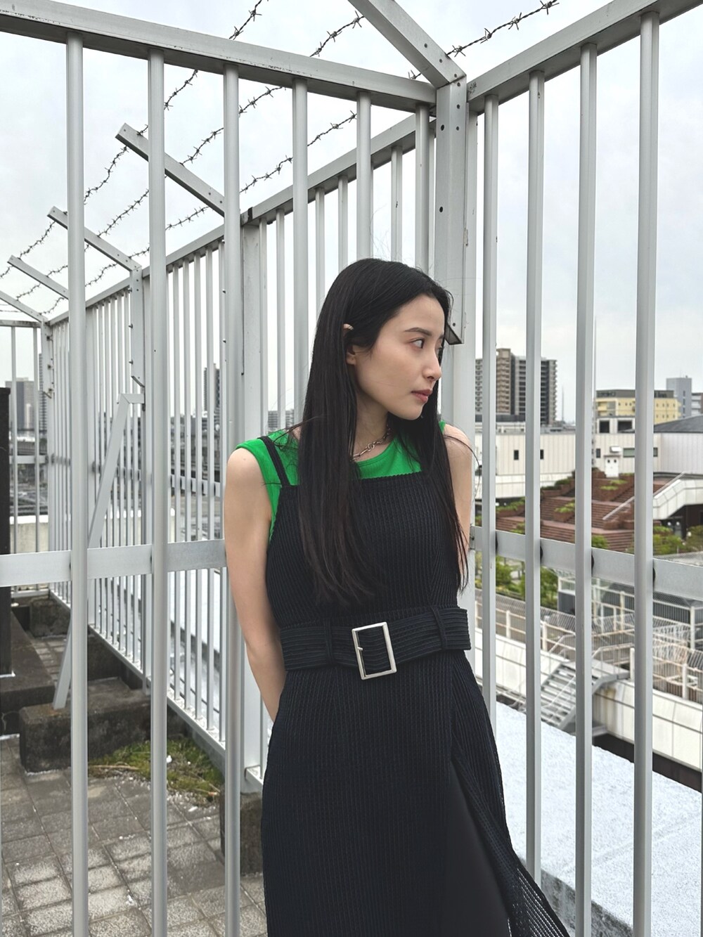 ブラック系のワンピース、グリーン系のタンクトップ、その他のサンダルを着用したレディースの春コーディネートの3枚目の写真