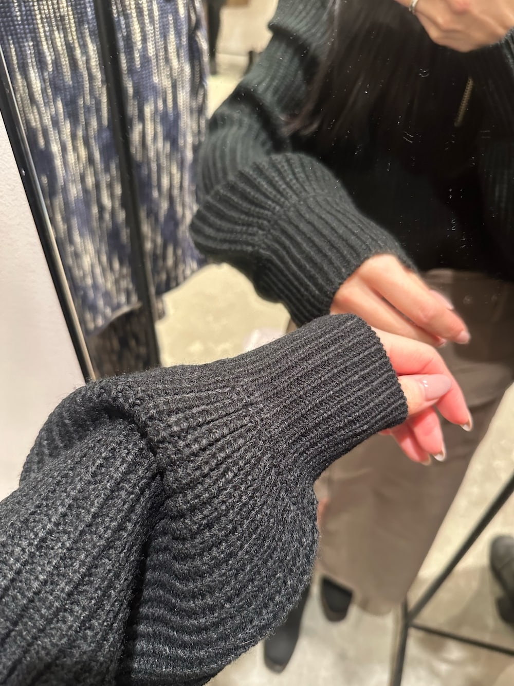 ブラウン系のスカート、ブラック系のニット/セーター、ブラック系のブーツを着用したレディースの冬コーディネートの5枚目の写真