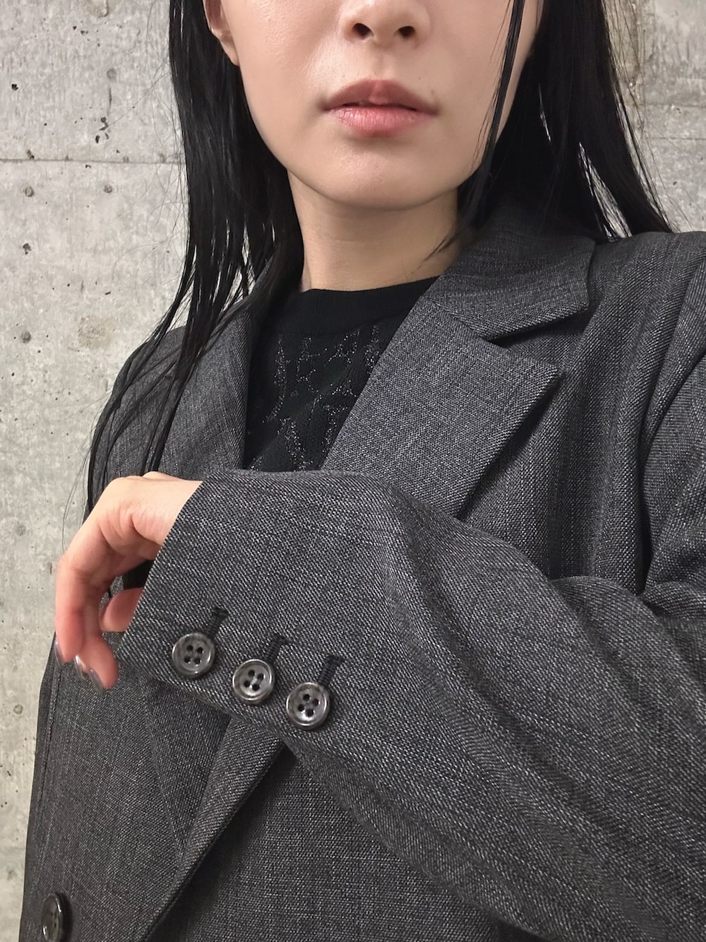 グレー系のスラックス、ブラック系のブーツ、グレー系のテーラードジャケットを着用したレディースの秋コーディネートの5枚目の写真