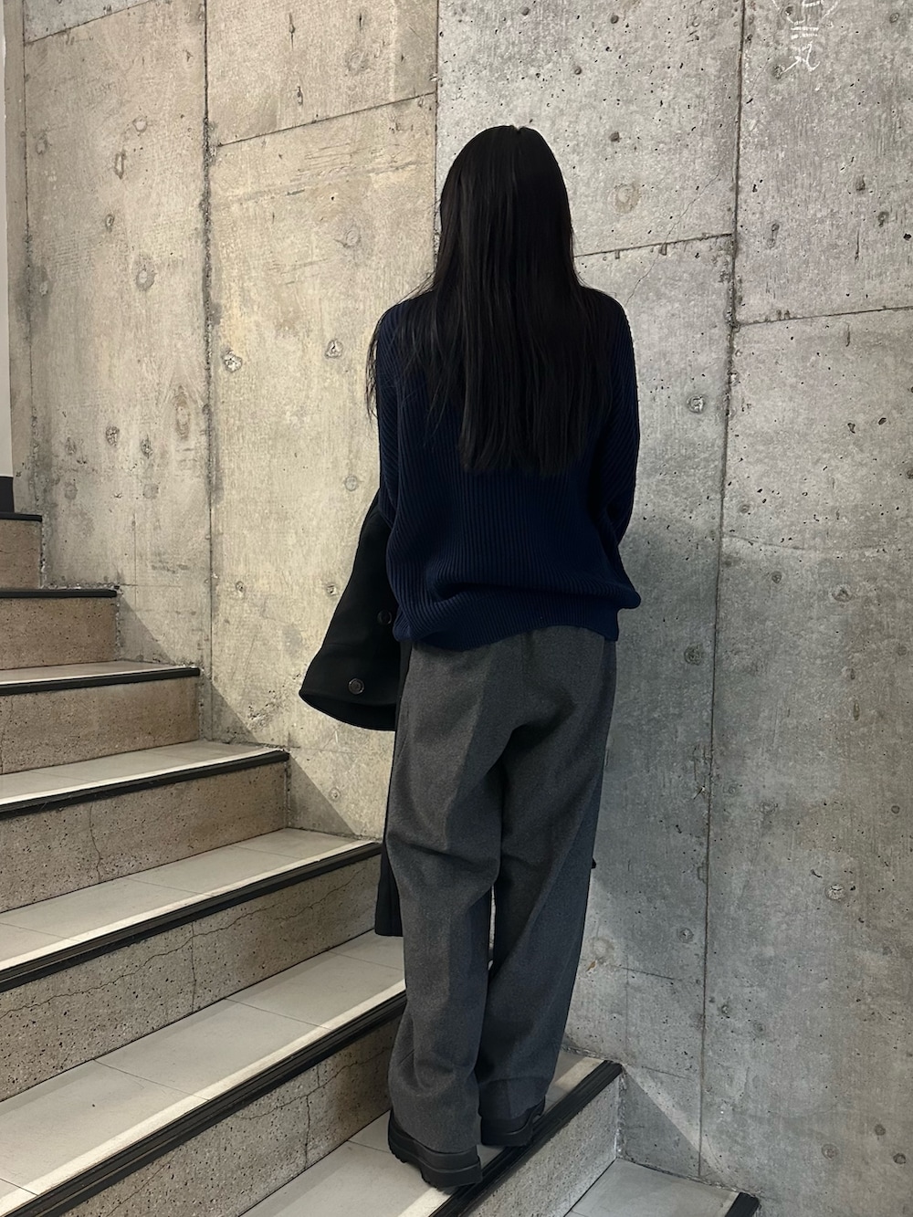 グレー系のスラックス、ブルー系のニット/セーターを着用したレディースの冬コーディネートの3枚目の写真