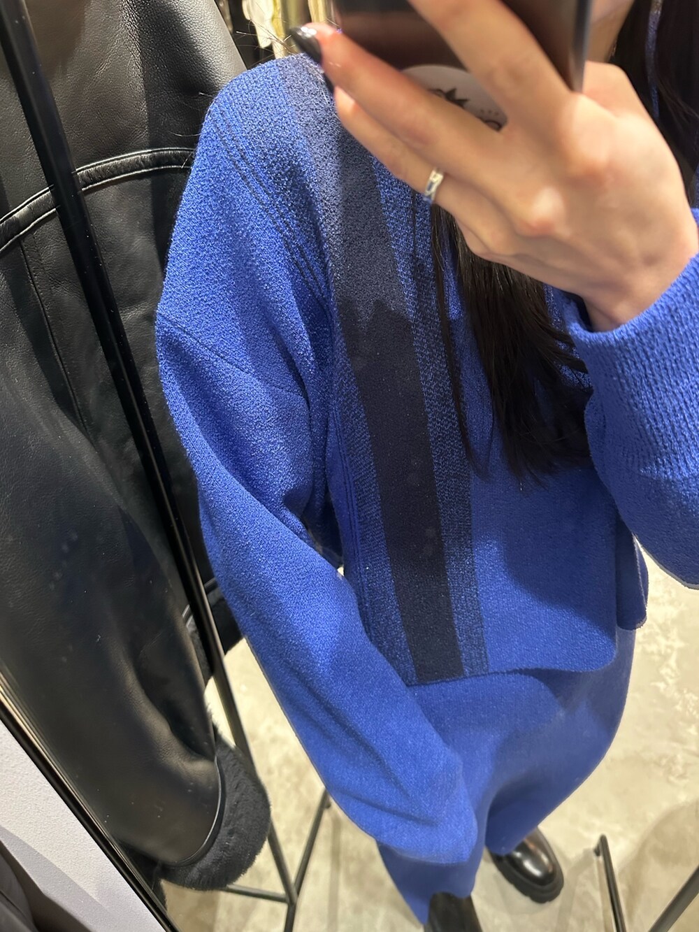 ブルー系のニット/セーター、ブルー系のスカート、ブラック系のブーツを着用したレディースの冬コーディネートの5枚目の写真