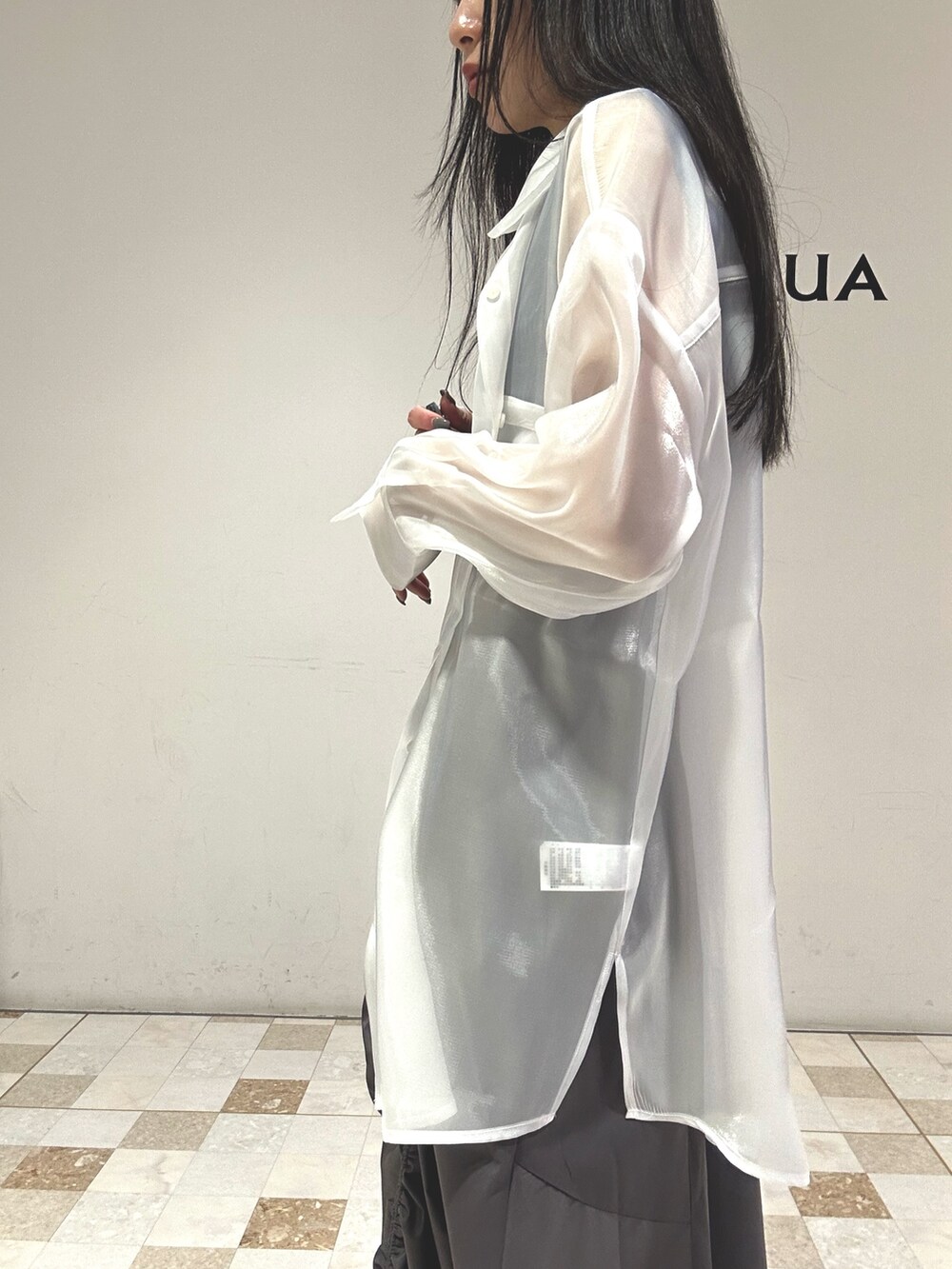 グレー系のスカート、ホワイト系のシャツ/ブラウス、ブルー系のタンクトップを着用したレディースの春コーディネートの7枚目の写真