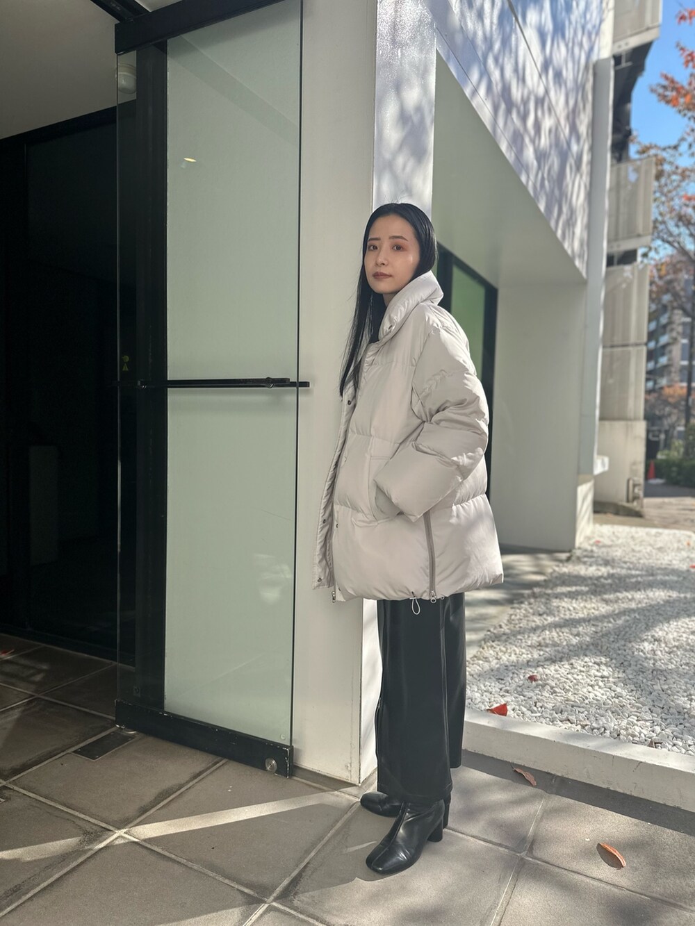 グレー系のダウンジャケット/コート、その他のニット/セーター、ブラック系のスカートを着用したレディースの冬コーディネートの2枚目の写真