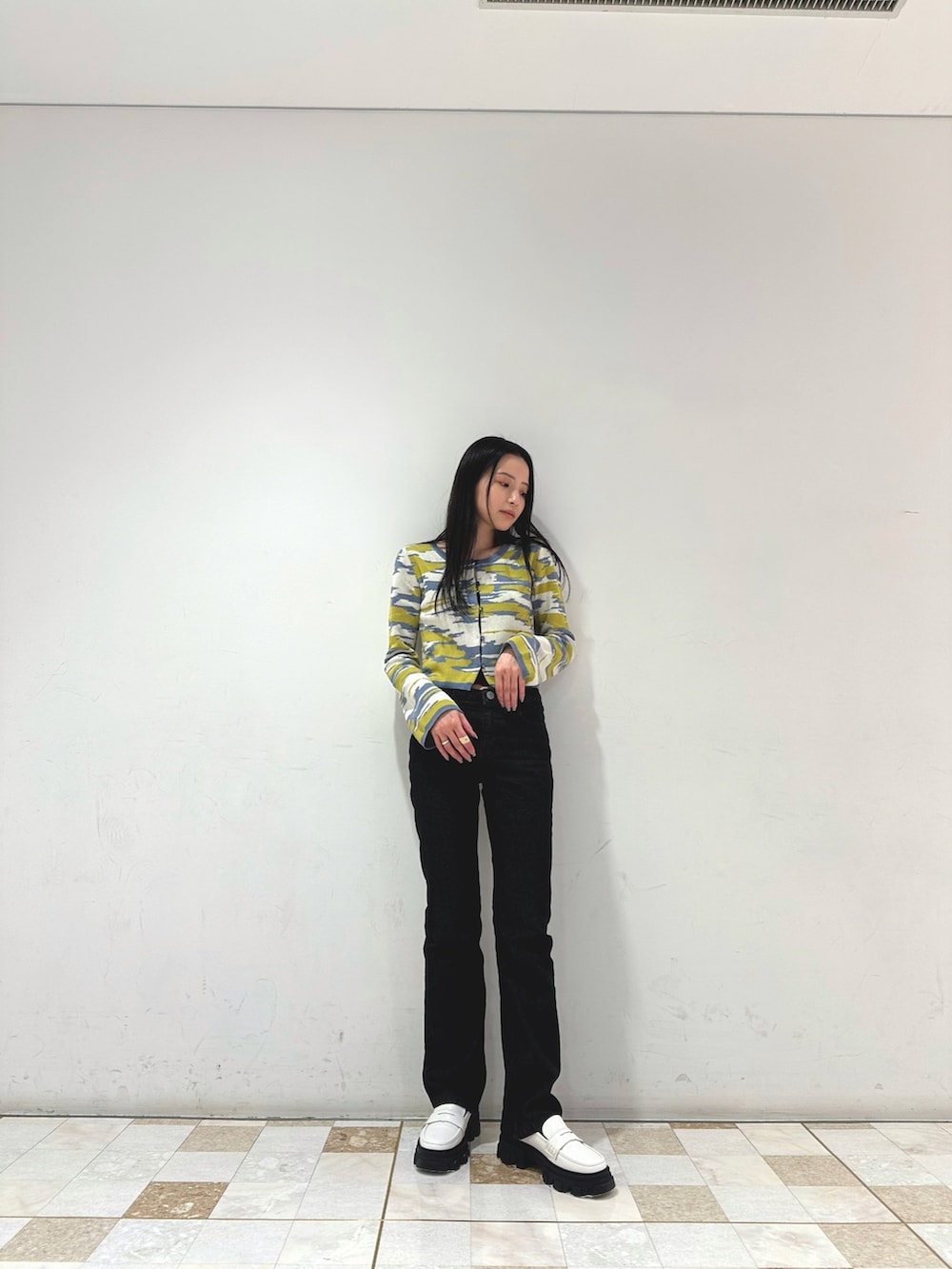 イエロー系のカーディガン/ボレロ、ブラック系のデニムパンツ、ホワイト系のローファーを着用したレディースの冬コーディネートの2枚目の写真