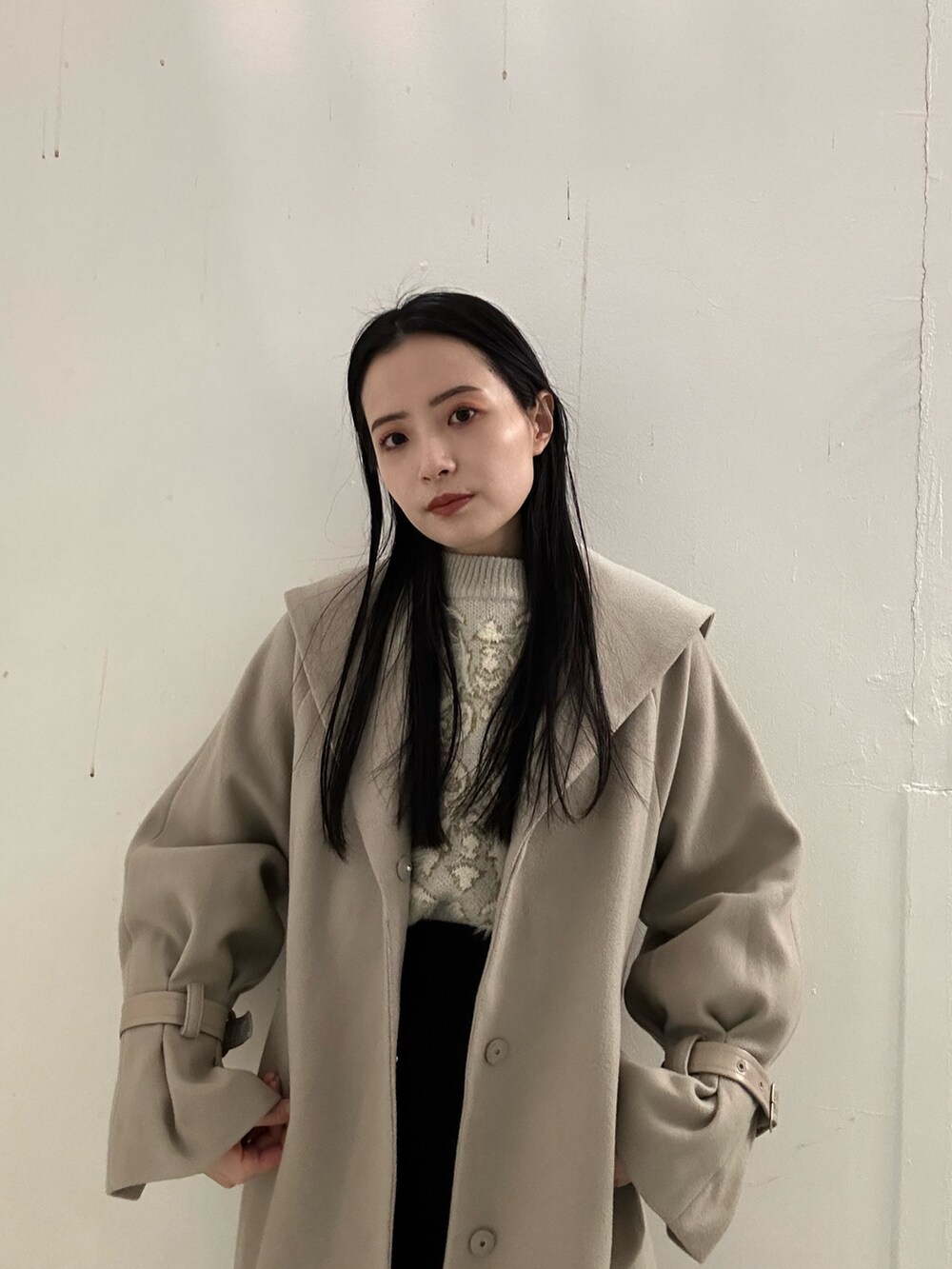 ブラック系のスカート、ホワイト系のニット/セーター、ブラウン系のブーツを着用したレディースの冬コーディネートの4枚目の写真