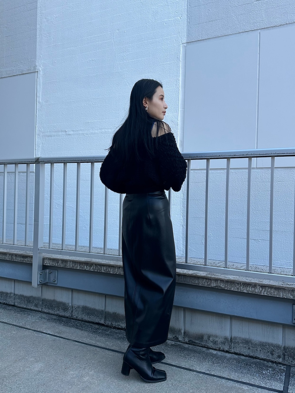 ブラック系のニット/セーター、ブラック系のスカートを着用したレディースの秋コーディネートの2枚目の写真