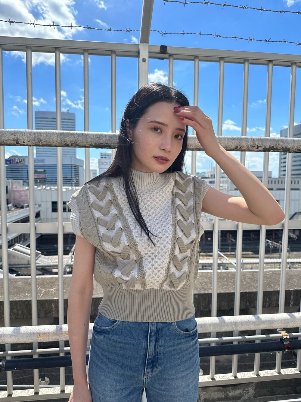 ホワイト系のニット/セーター、ブルー系のデニムパンツ、ブラック系のブーツを着用したレディースの夏コーディネートの5枚目の写真