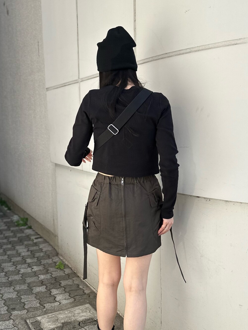 ベージュ系のスカート、ブラック系のTシャツ/カットソー、ブラック系のブーツを着用したレディースの冬コーディネートの8枚目の写真