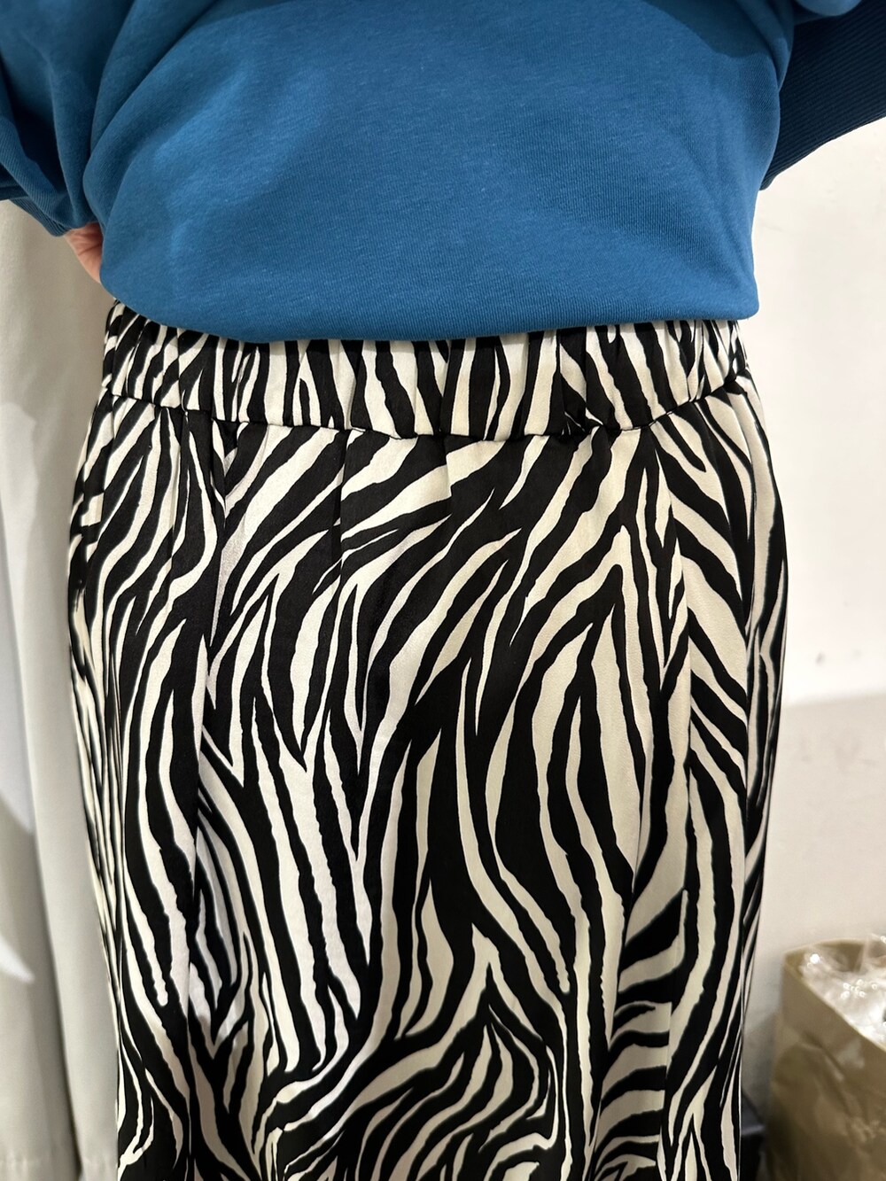 ブルー系のTシャツ/カットソー、ホワイト系のスカート、ブラック系のキャップを着用したレディースの春コーディネートの8枚目の写真