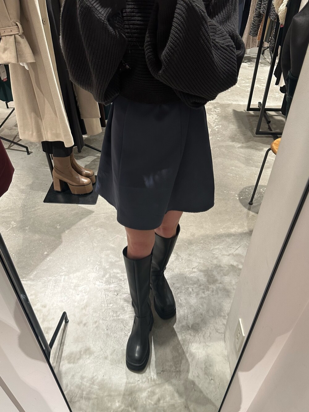 グレー系のワンピース、グレー系のダウンジャケット/コート、ブラック系のブーツを着用したレディースの冬コーディネートの8枚目の写真