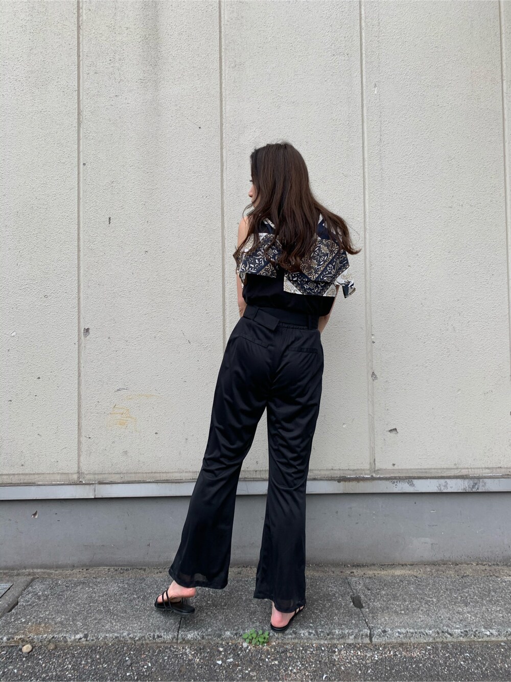 ブラック系のスラックス、ブラック系のサンダル、ブラック系のTシャツ/カットソーを着用したレディースの春コーディネートの4枚目の写真