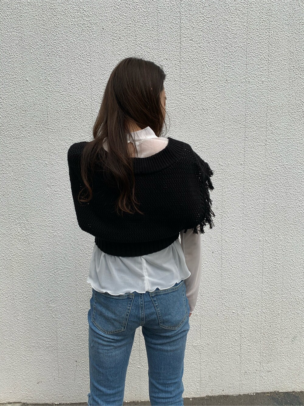 ブルー系のデニムパンツ、ブラック系のサンダル、ブラック系のニット/セーターを着用したレディースの春コーディネートの3枚目の写真