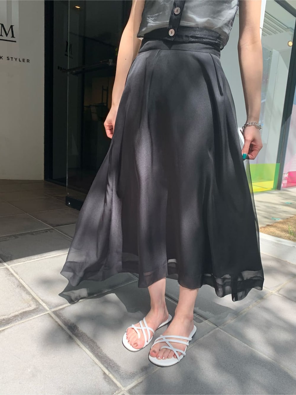 ホワイト系のサンダル、ブラック系のスカート、ブラック系のTシャツ/カットソーを着用したレディースの夏コーディネートの4枚目の写真